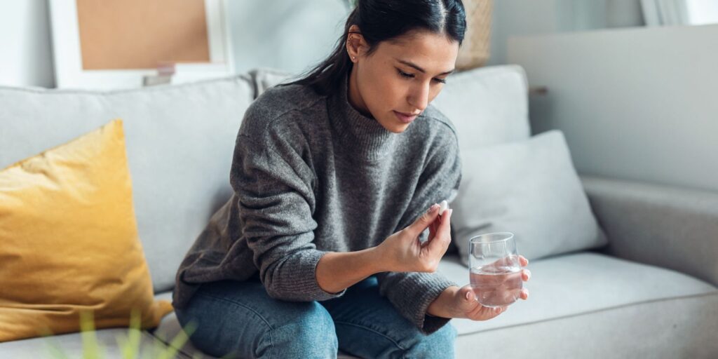 young woman holding a pill in her hand - percocet